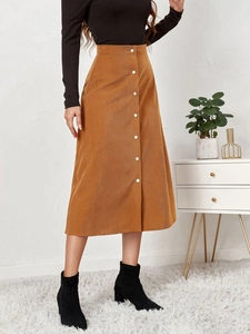 Close-up of brown corduroy midi skirt with high waist and decorative white buttons