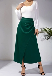 Détail de l'élégante jupe en satin vert foncé à taille haute et plis raffinés
