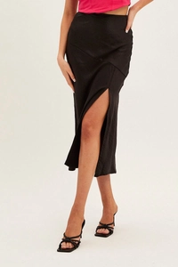 Detail of high waist black satin midi skirt featuring side slit and smooth glossy fabric