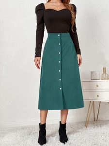 Detailed texture of dark green corduroy skirt with single-breasted buttons and high waist