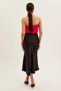 Rear view of sleek black high waist satin maxi skirt with a smooth glossy finish