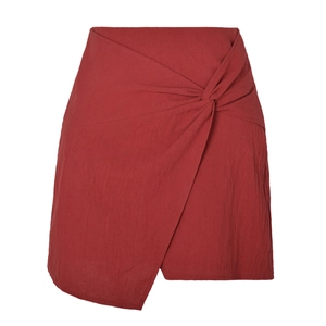 Détail de la jupe taille haute rouge foncé avec nœud torsadé et texture en coton et lin