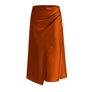 Détail de la jupe en satin caramel montrant la taille plissée et l'ourlet soyeux