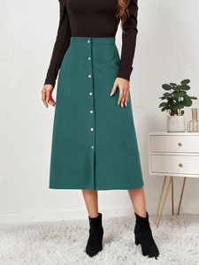 Detail view of high waist dark green corduroy skirt with silver buttons and A-line cut
