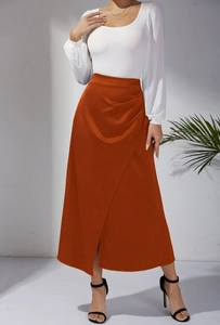 Détail d'une jupe en satin taille haute orange avec plis élégants et fente sur le côté