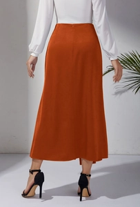 Détail d'une jupe longue satinée orange à taille haute avec fermeture éclair et coupe sirène