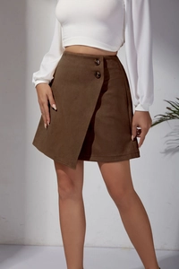 Detail of high waisted brown faux suede mini skirt with asymmetrical hem and buttons