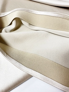 Detail view of champagne satin skirt featuring a high elastic waistband and silk texture