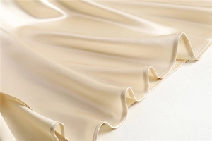 Detail of champagne satin skirt hem showing delicate stitching and elegant draped folds