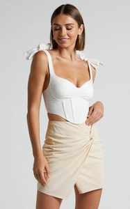 Détail de jupe asymétrique en lin à taille haute avec nœud torsadé et fermeture éclair