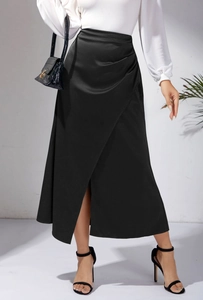 Détail d'une jupe midi en satin noir à taille haute avec fente latérale et plis élégants
