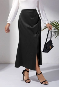 Détail de la jupe longue en satin noir à taille haute avec fente latérale et drapé fluide