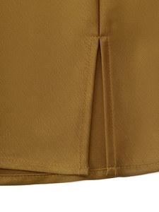 Détail de l'ourlet fendu et double couture sur une jupe en satin taille haute ocre