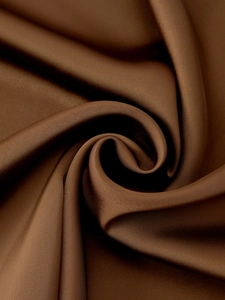 Detailed macro view of high-waist brown satin skirt fabric with smooth woven texture