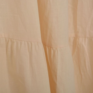 Détail du design plissé multicouche sur un tissu en coton et lin respirant pour femme