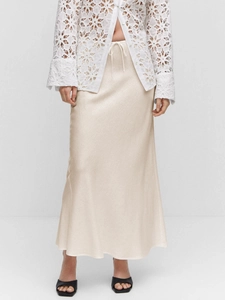 Detail of champagne satin maxi skirt highlighting smooth fabric and drawstring waist tie