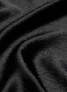 Detailed macro view of black acetate satin fabric with pleated texture and silky sheen