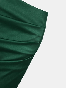 Gros plan sur la texture du tissu satiné vert foncé avec des reflets soyeux et brillants