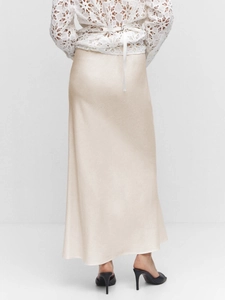 Detail of high-waist satin maxi skirt in champagne gold with elegant silky texture