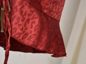 Gros plan détaillé sur le satin jacquard léopard rouge avec volants et lacet latéral