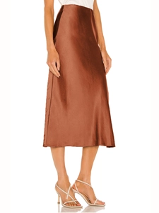 Close-up of caramel satin midi skirt showing smooth texture and elegant side slit
