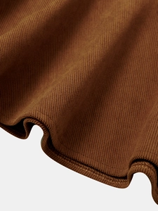 Macro close-up of brown corduroy fabric texture and neat hem stitching details
