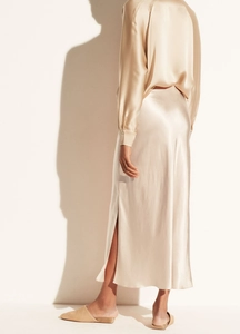 Detail of champagne gold satin skirt featuring an elegant side slit and smooth draped fabric