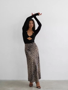 Vista intera di una gonna midi in raso leopardato con body nero a maniche lunghe