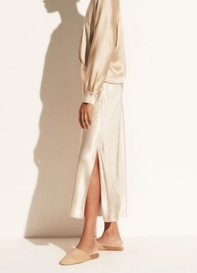 Detail of champagne gold satin maxi skirt with high side slit and silky pearl luster finish