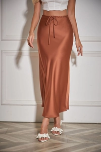 Detail of rust red satin skirt showing smooth silk texture and drawstring waist design
