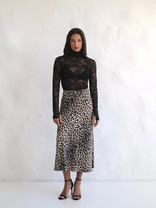Dettaglio della gonna midi in raso leopardato abbinata a un top in pizzo a collo alto