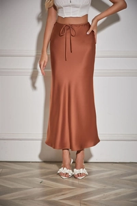 Detail of elegant copper satin midi skirt featuring a high waist drawstring and silky texture