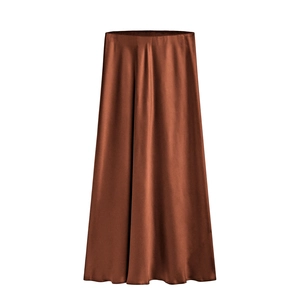 Detail of high-gloss satin fabric texture and deep caramel drape on a long skirt