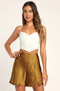 Détail d'une mini-jupe trapèze en satin doré à taille haute avec fente latérale chic