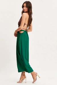 Detail of high-waisted green maxi skirt with side cutouts and elastic waist design