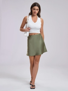Detail of elegant green satin skirt paired with a white ribbed knit sleeveless top