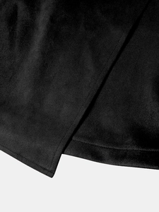 Detail shot of black suede fabric showing irregular hem stitching and overlap design
