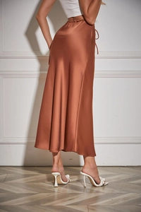 Detailed view of the smooth caramel satin midi skirt fabric with glossy silk texture