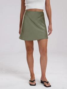 Detail of olive green satin mini skirt with silky texture and elastic high waist design
