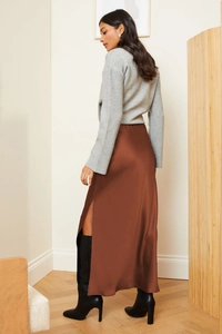 Detailed view of dark brown satin maxi skirt with high side slit and grey knit texture