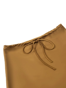 Close-up of brown satin skirt featuring a drawstring waist and fine sewing details