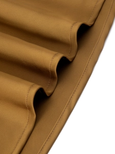 Close-up of ginger yellow satin skirt showing twill fabric texture and fine double stitching