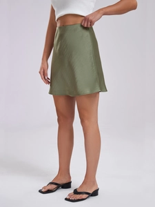 Detailed view of olive green satin mini skirt with smooth glossy fabric texture