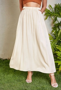 Detail view of high-waist cream satin maxi skirt featuring side cut-outs and elastic band