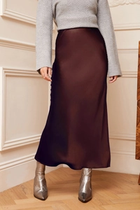 Detailed view of dark chocolate satin midi skirt with elegant glossy texture and drape