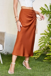 Detail of satin midi skirt showing adjustable side drawstring ruching and silky fabric texture