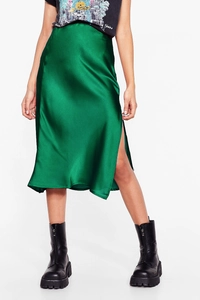 Detail view of the green satin midi skirt showing side slit and smooth silk luster