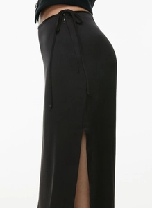 Detail of high waist black satin skirt featuring a delicate waist tie and side slit design