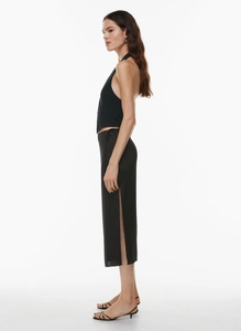 Detail view of high waist satin skirt side slit and black halter neck top set