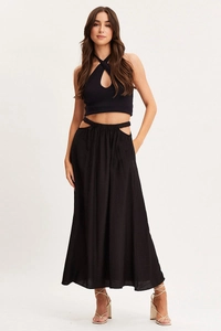 Detail of black two-piece set featuring a halter top and high-waisted side cutout maxi skirt